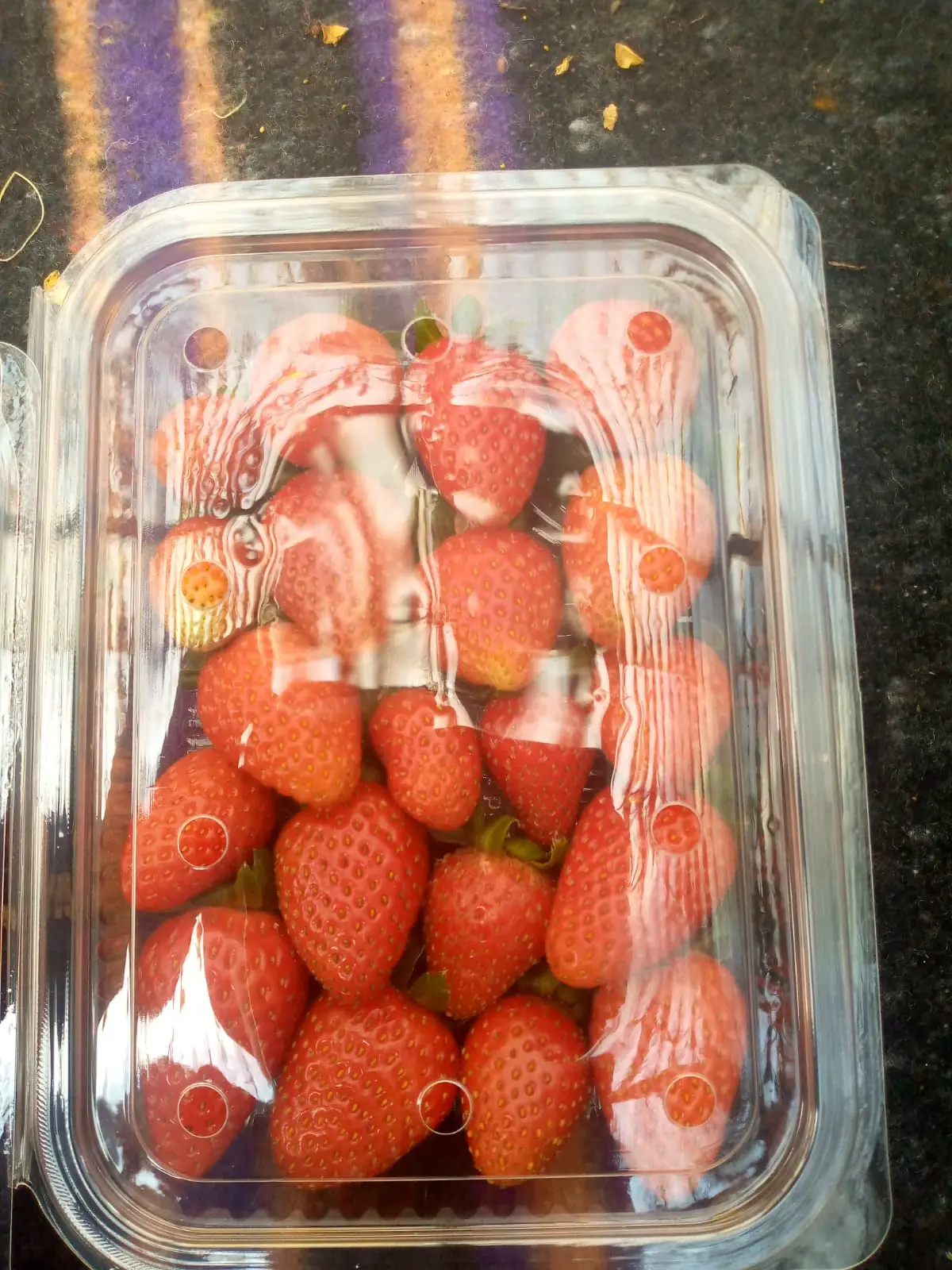 A punnet of red greenhouse strawberries as delivered